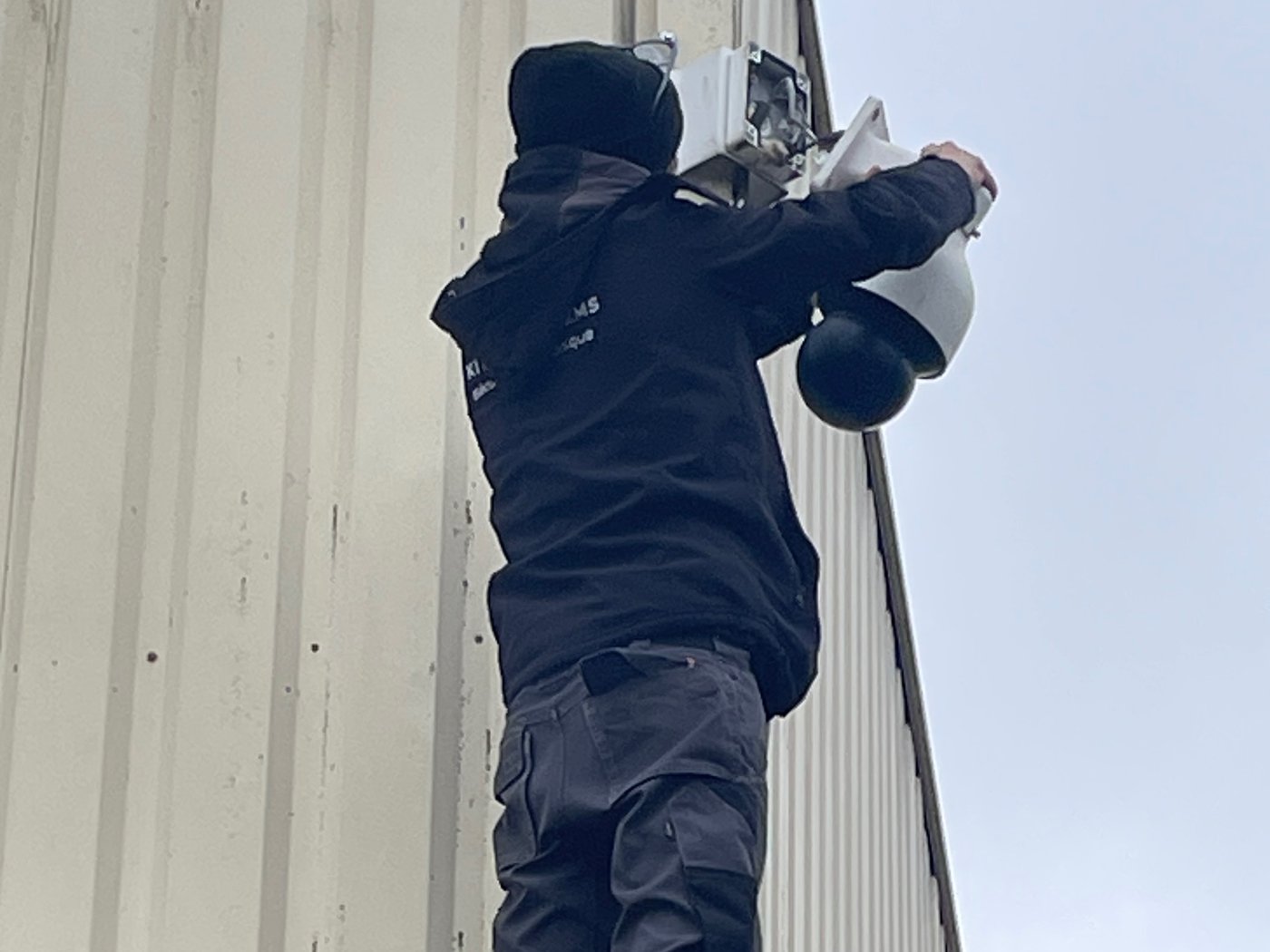 Pose d'une caméra en façade d'un bâtiment de stockage